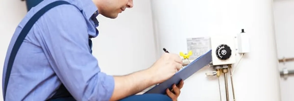 Water heater repair technician inspecting the unit and recording service notes in San Diego, CA